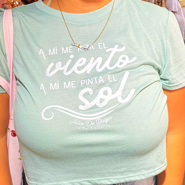 Camisa con frase de "A Julia De Burgos":  "Tú te rizas el pelo y te pintas; yo no, a mí me riza el viento, a mí me pinta el sol."