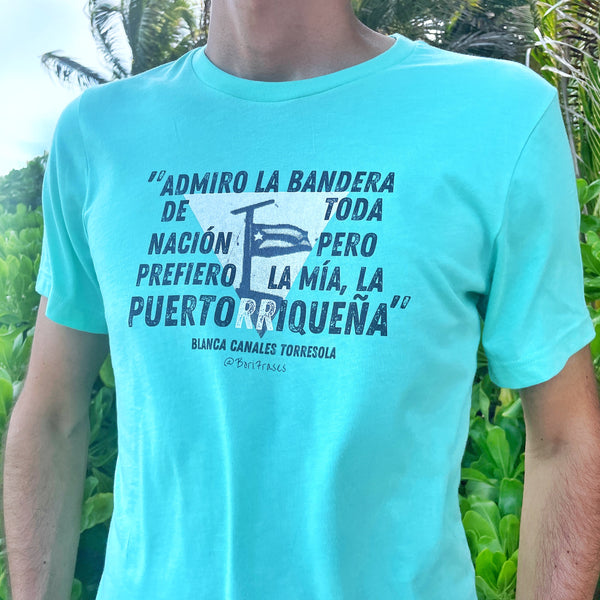 Camisa t-shirt con la bandera que izó Blanca Canales en el pueblo de Jayuya, Puerto Rico, durante la Revolución Nacionalista de 1950 y su frase: "Yo admiro la bandera americana, como admiro la bandera de cualquier otra nación, pero prefiero la mía, la puertorriqueña.” Shirt with quote from Puerto Rican woman revolutionary