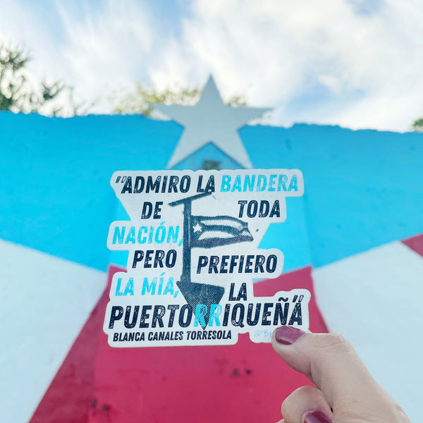 Sticker con la bandera que izó Blanca Canales en el pueblo de Jayuya, Puerto Rico, durante la Revolución Nacionalista de 1950 y su frase: "Yo admiro la bandera americana, como admiro la bandera de cualquier otra nación, pero prefiero la mía, la puertorriqueña.” Sticker with quote from a Puerto Rican woman revolutionary