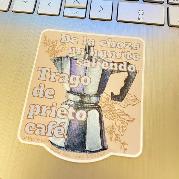 Sticker con las hojas de café, la famosa greca y la siguiente frase del poema "Café prieto" de Luis Lloréns Torres: "De la choza que está en la vereda, un humito saliendo se ve. La ventana se abre. Y la doña me da un trago de prieto café."