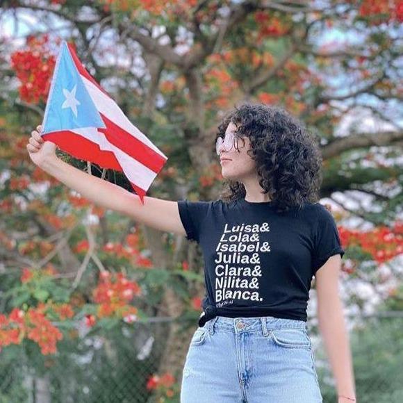 T-shirt negra con los nombres de las #heroínaspr, siete mujeres históricas, latinas, puertorriqueñas y feministas. 